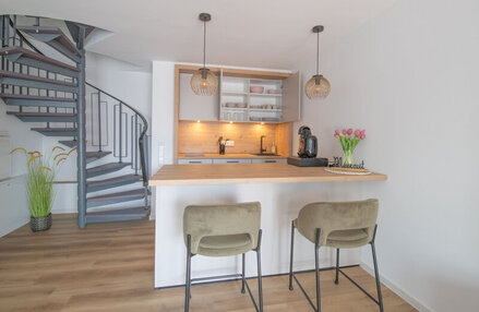 Kleine Küche mit Barhockern und Esstheke